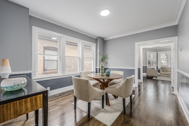 dining space with wood-type flooring and crown molding