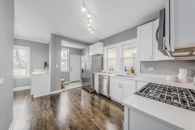 kitchen with light stone countertops, dark hardwood / wood-style flooring, stainless steel appliances, sink, and white cabinets