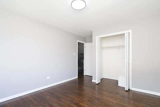 unfurnished bedroom featuring dark hardwood / wood-style floors and a closet