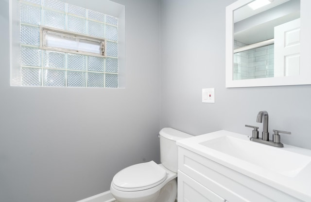 bathroom with a shower with door, vanity, and toilet