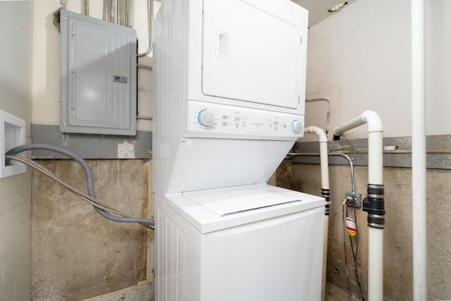 washroom with electric panel and stacked washer and clothes dryer