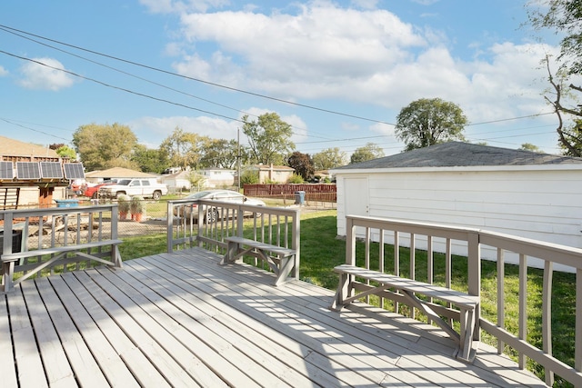 wooden deck featuring a lawn