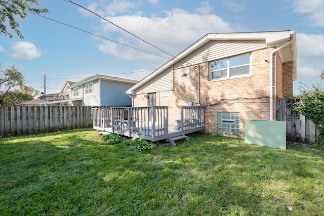 rear view of property with a deck and a lawn