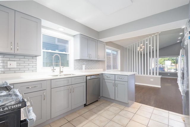 kitchen featuring gray cabinetry, sink, tasteful backsplash, decorative light fixtures, and appliances with stainless steel finishes