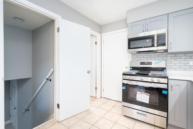 kitchen featuring decorative backsplash, light tile patterned floors, and stainless steel appliances