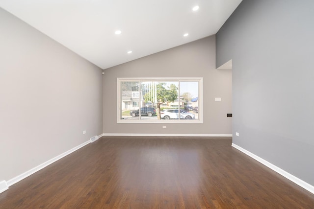 spare room with dark wood-type flooring and vaulted ceiling