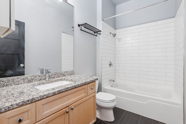 full bathroom featuring tiled shower / bath combo, vanity, hardwood / wood-style floors, and toilet