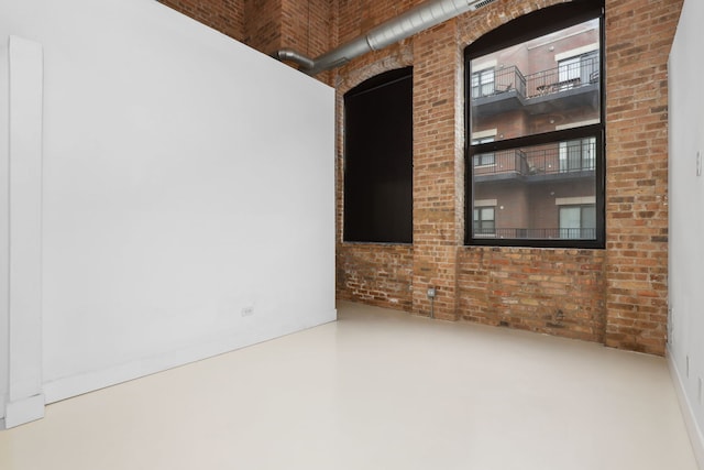 empty room featuring concrete flooring and brick wall