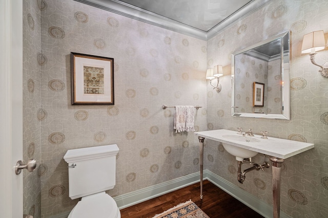 bathroom with toilet, crown molding, hardwood / wood-style floors, and sink