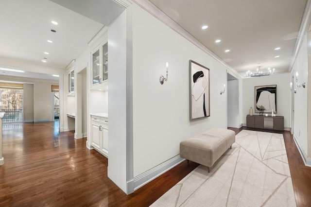 hallway featuring hardwood / wood-style flooring, built in features, and ornamental molding