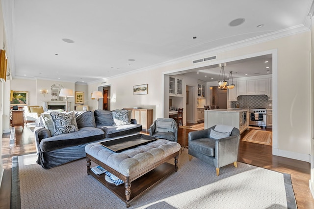 living room featuring a wealth of natural light, light hardwood / wood-style flooring, and ornamental molding