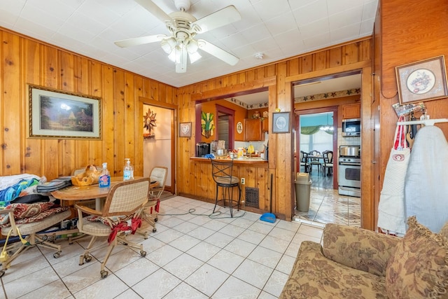 dining space featuring wood walls and ceiling fan