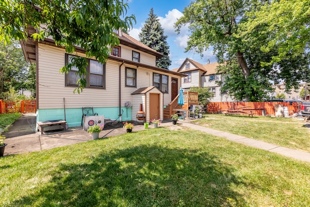 rear view of house featuring a yard and a patio area