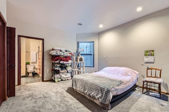 bedroom featuring ensuite bathroom and light carpet