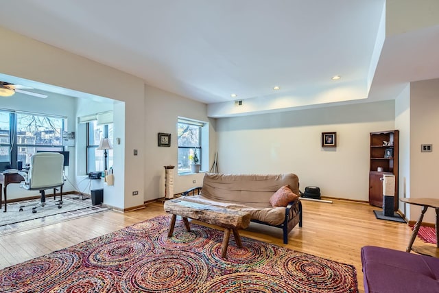 living room featuring ceiling fan, a healthy amount of sunlight, and light wood-type flooring