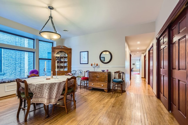 dining room with light hardwood / wood-style floors and a healthy amount of sunlight