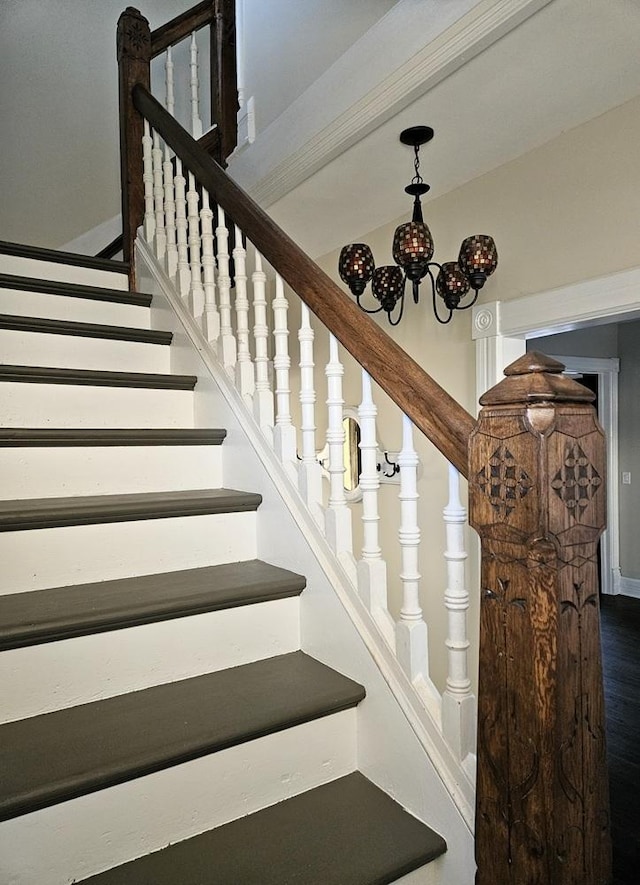 stairs featuring a chandelier and wood finished floors