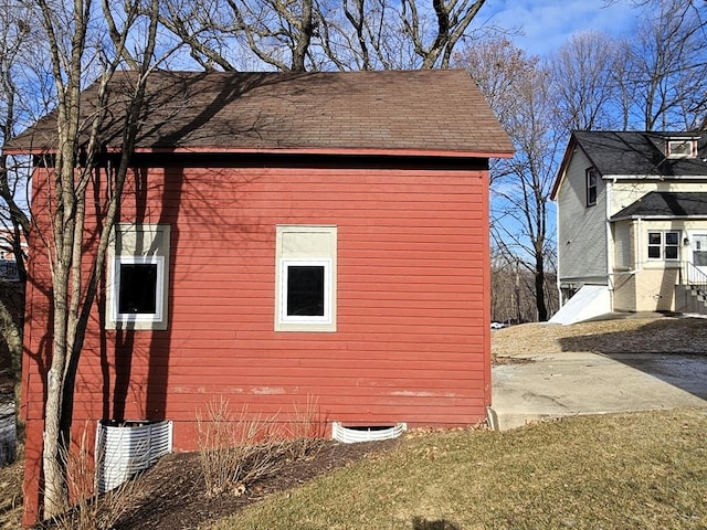 view of side of home featuring entry steps and a shingled roof