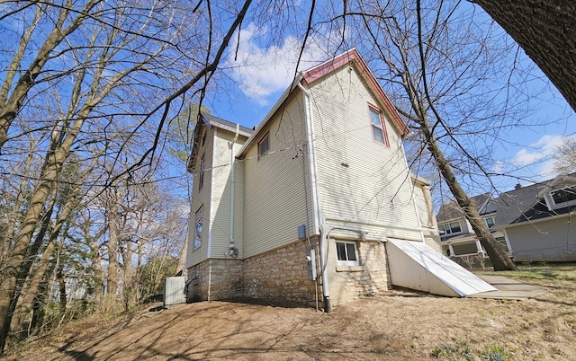 back of property with central AC unit and stone siding