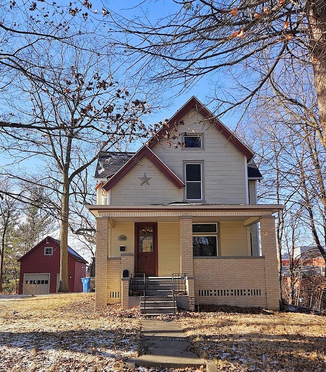 view of front of property with covered porch, a garage, and an outdoor structure