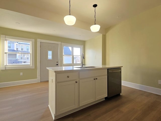 kitchen with dishwasher, a center island with sink, sink, hanging light fixtures, and white cabinets