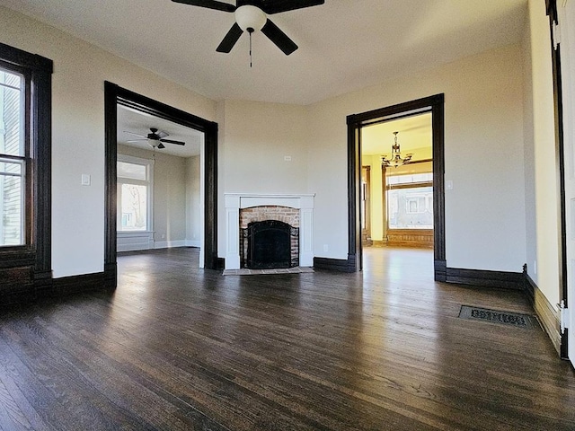 unfurnished living room with plenty of natural light, dark hardwood / wood-style floors, and a fireplace