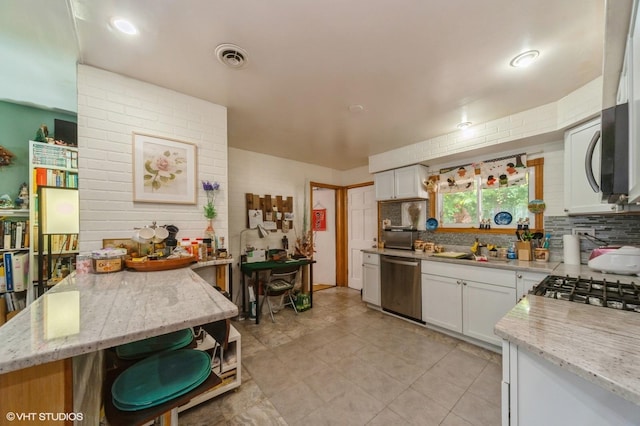 kitchen with backsplash, dishwasher, and white cabinets