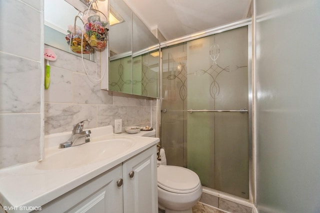 full bath featuring vanity, a shower stall, tile walls, toilet, and backsplash