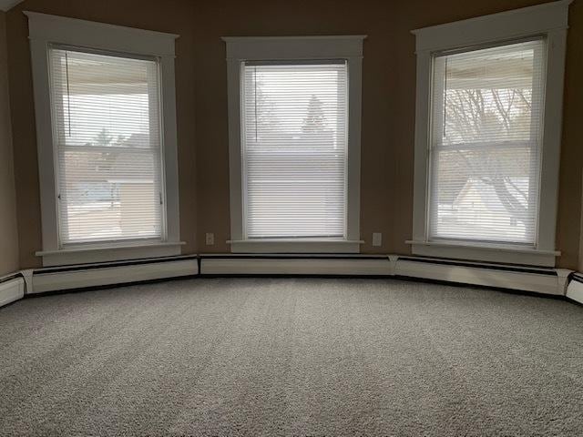 unfurnished room with a baseboard radiator and carpet flooring