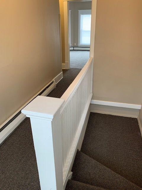 staircase featuring baseboard heating and carpet