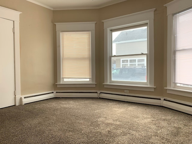 spare room featuring baseboard heating and crown molding