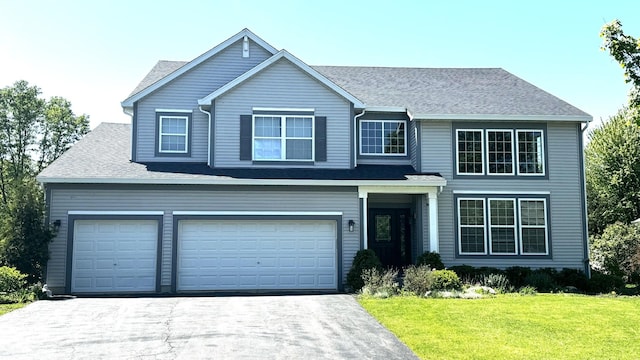 view of property with a front yard and a garage