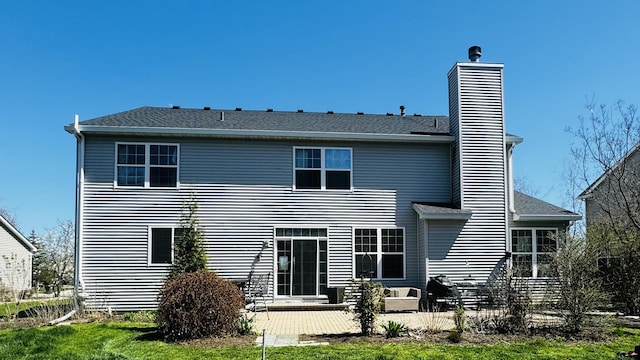 rear view of property with a patio and a lawn