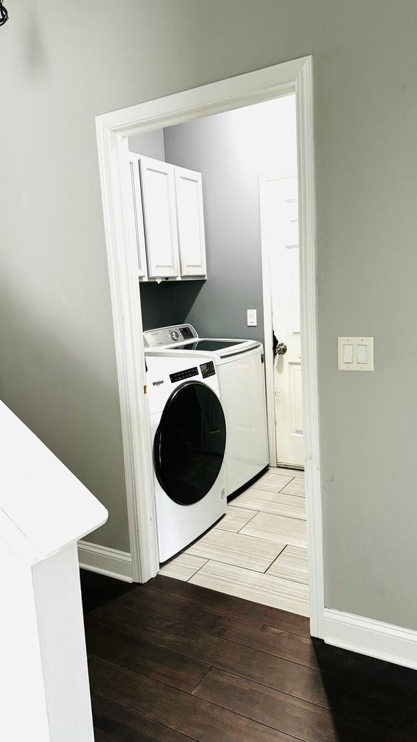 laundry room with washer and dryer and cabinets