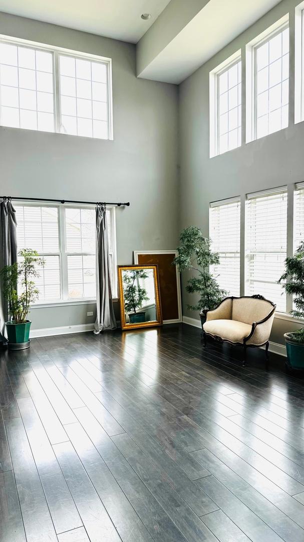 unfurnished living room with a high ceiling and dark hardwood / wood-style flooring