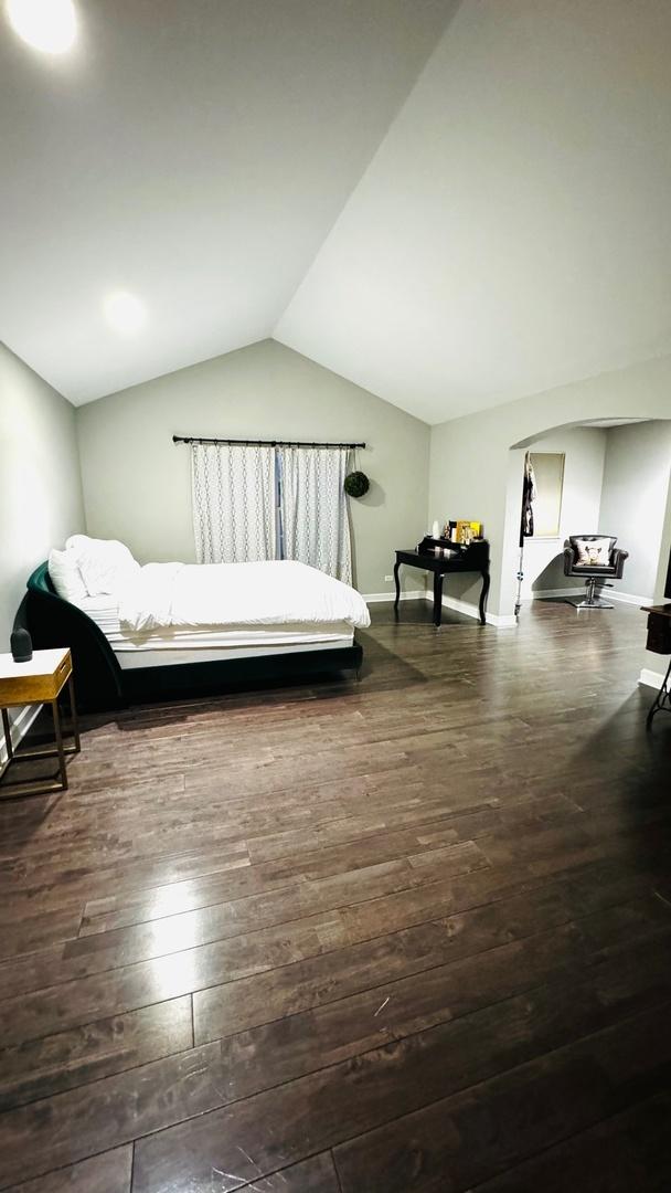 bedroom featuring lofted ceiling and dark hardwood / wood-style floors