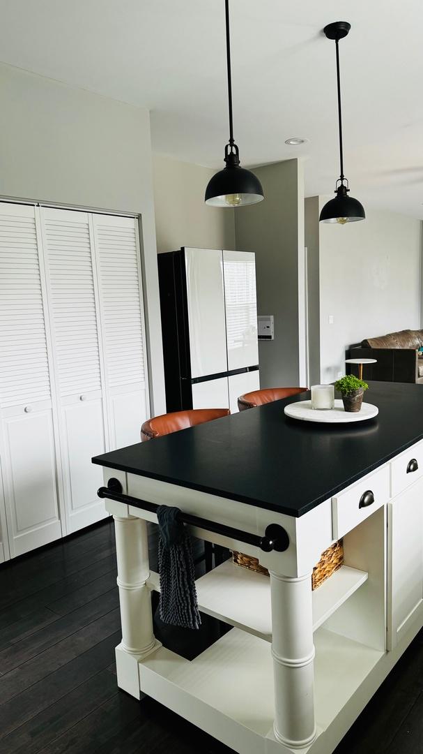 kitchen featuring dark hardwood / wood-style flooring, white cabinets, white fridge, and hanging light fixtures