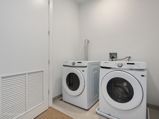 clothes washing area featuring light hardwood / wood-style floors and independent washer and dryer