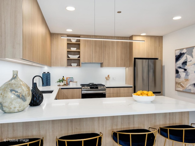 kitchen featuring a breakfast bar, sink, stainless steel appliances, kitchen peninsula, and light brown cabinetry