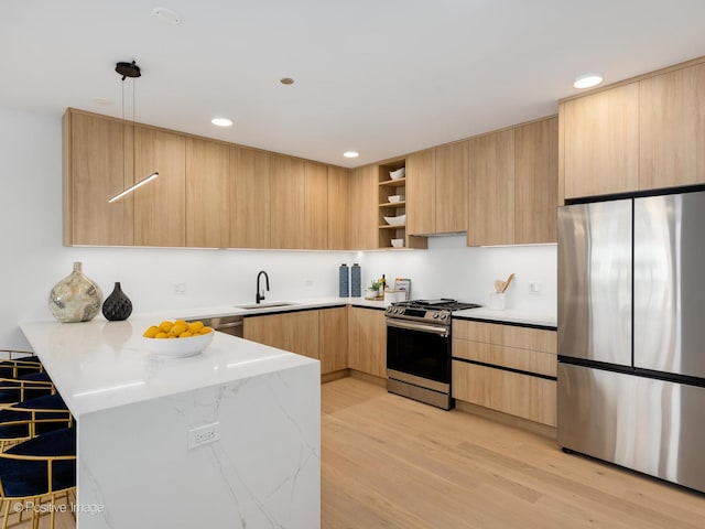 kitchen featuring light brown cabinets, sink, stainless steel appliances, kitchen peninsula, and light hardwood / wood-style floors