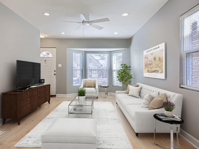 living room with ceiling fan and light hardwood / wood-style flooring