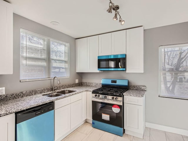 kitchen with white cabinetry, sink, a wealth of natural light, and appliances with stainless steel finishes