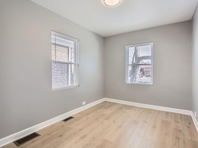 spare room featuring hardwood / wood-style flooring and plenty of natural light