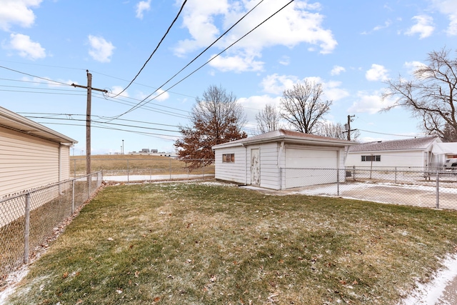 view of yard with a garage and an outbuilding