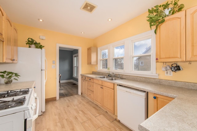 kitchen with light brown cabinets, white appliances, and light hardwood / wood-style flooring