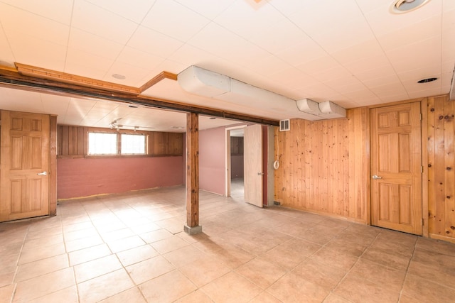 basement featuring wooden walls