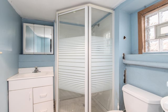 bathroom with toilet, vanity, and walk in shower