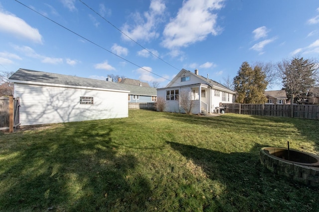 rear view of property with an outdoor structure and a yard