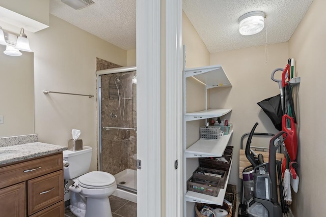 bathroom featuring tile patterned floors, vanity, an enclosed shower, and toilet