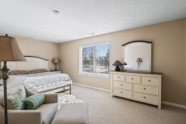 bedroom with a textured ceiling and light colored carpet